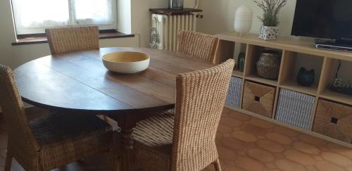 un tavolo in legno con sedie e una ciotola sopra di Charmante Maison à Recloses a Recloses