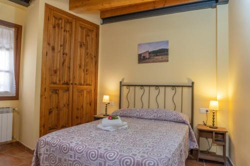 a bedroom with a bed with a purple bedspread at Casa El Centro in Beceite