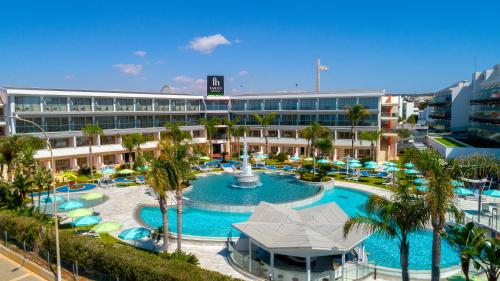 ein Resort mit einem großen Pool und einem Brunnen in der Unterkunft Faros Hotel Ayia Napa in Ayia Napa
