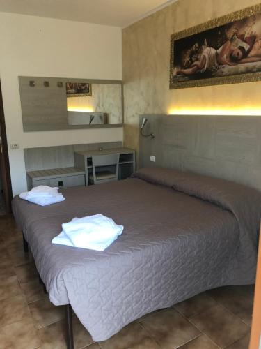 um quarto com uma cama com duas toalhas em Hotel Posta em Rota d'Imagna