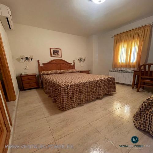 a bedroom with a bed and a table and chairs at Hotel Venta del Pobre in Níjar
