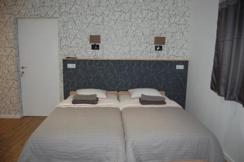 two beds sitting in a room with a wall at Vila Phoenix in Călimăneşti