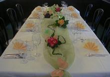 a table with a flower arrangement in a green vase at Hotel Goldener Karpfen in Aschaffenburg