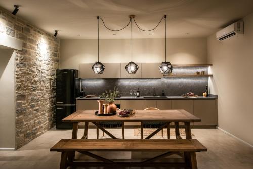 a kitchen with a wooden table in a room at Kamilari Luxury Residences in Kamilari