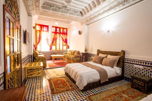 a bedroom with a bed and a living room at Riad Sayeda Al Hora in Fès