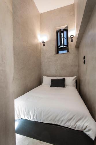 a bedroom with a white bed with a window at Case D'a Mare Mondello in Mondello