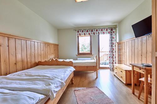 a bedroom with a bed and a desk and a window at Pokoje Gościnne Stoch in Ząb