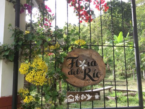 a gate with a sign that reads irzu del rug at Cabana del Rio Lejos Pijao, Finca Flora del Rio in Pijao