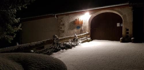 a building with a snow covered doorway with a light at Maison d'hôtes et SPA La Boucotte in Vellerot-lès-Vercel