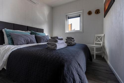 um quarto com uma cama grande e toalhas em At Sea Zoutelande - Nieuwstraat 15a em Zoutelande
