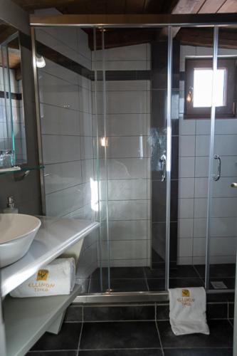 a bathroom with a glass shower and a sink at Ellinon Thea Arachova in Arachova