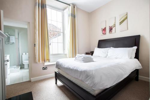 ein Schlafzimmer mit einem großen Bett und einem Fenster in der Unterkunft Elegant Georgian apartment near Clifton Village in Bristol