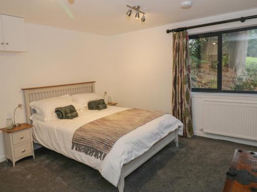 a bedroom with a bed and a large window at Dunaivon Cottage in Helensburgh