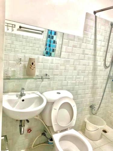 a white bathroom with a toilet and a sink at Cozy Central - Near arca south signal taguig in Manila
