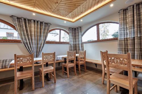 a dining room with a table and chairs and windows at Pokoje Gościnne Stoch in Ząb