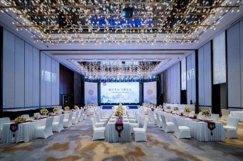 a large banquet hall with white tables and white chairs at Crowne Plaza Shenzhen Nanshan by IHG in Shenzhen