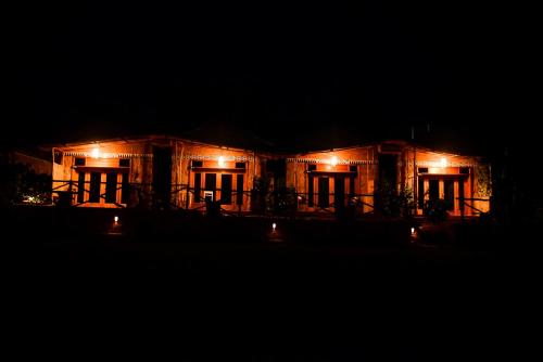 Una casa iluminada por la noche con luces encendidas en Akagera Transit Lodge en Akagera