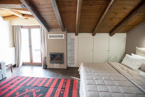 a bedroom with a large bed and a fireplace at Ellinon Thea Arachova in Arachova