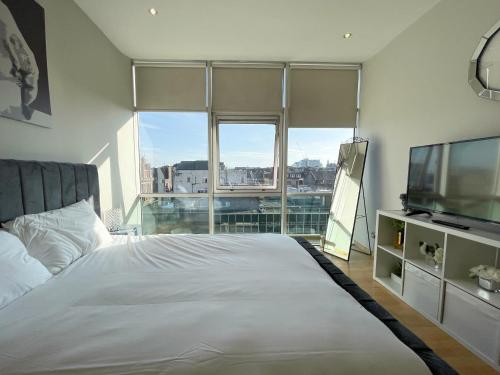 1 dormitorio con 1 cama y TV de pantalla plana en City Centre 2-Bed Apartment Parking Jacuzzi Bath, en Glasgow