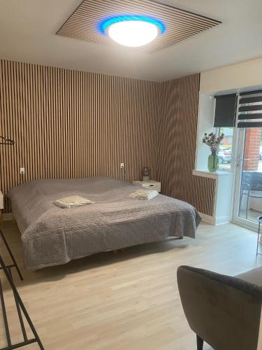 a bedroom with a bed with a blue light on the ceiling at Just Sleep Delux in Brande