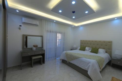 una camera con 2 letti, tavolo da trucco e specchio di Executive Apartments ad Amman