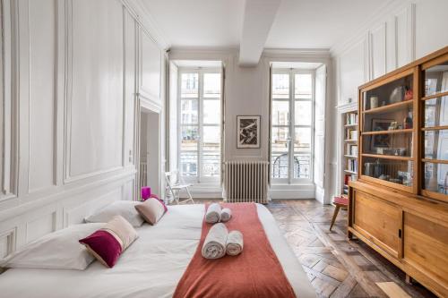une chambre avec un grand lit avec des serviettes dessus dans l'établissement L'Alcôve - Volume et Elégance en coeur de ville, à Rennes