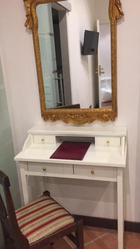 a white dressing table with a mirror and a chair at Hotel Caracciolo in Rome