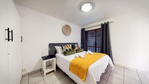 a bedroom with a bed with a yellow blanket on it at San Lameer Villa 1928 by Top Destinations Rentals in Southbroom