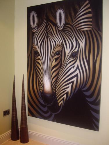 een schilderij van twee zebra's aan een muur bij Portland Apartments in Cheltenham