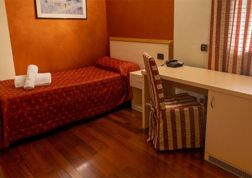 a hotel room with a bed and a desk and a chair at Caprice in Avigliana