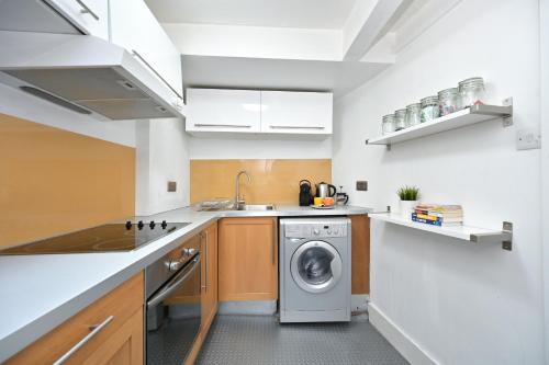 a kitchen with a washer and a washing machine at Soho, Piccadilly & Chinatown - Two Bedroom & Two Double Beds Apartment in London
