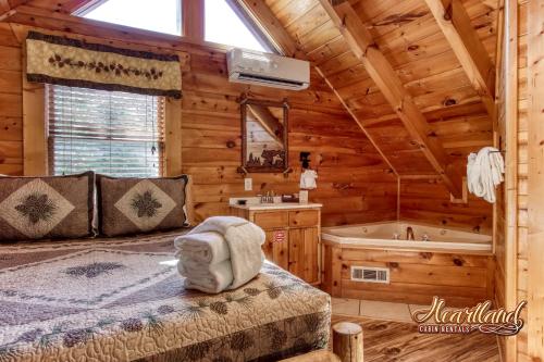 a log cabin bedroom with a bed and a tub at God's Grace in Pigeon Forge