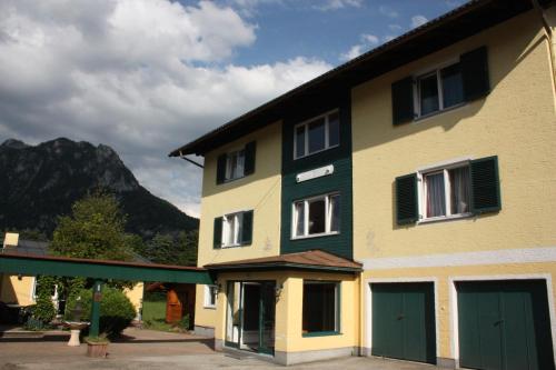 a building with green doors and a mountain at Frühstückspension Haus Ahamer in Ebensee