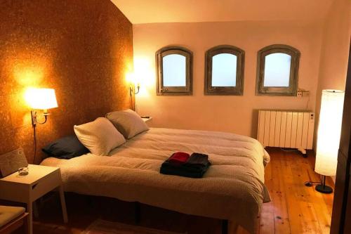 a bedroom with a large bed with three windows at CA LA ROSITA in Solsona