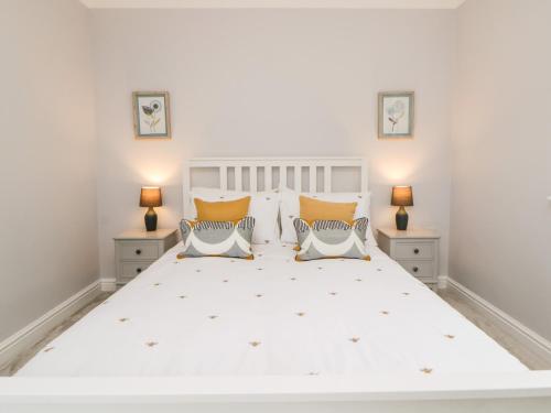 a bedroom with a large white bed with two lamps at Siena Cottage, 41a Kents Lane in Torquay