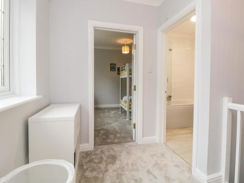 a white bathroom with a toilet and a tub at Siena Cottage, 41a Kents Lane in Torquay