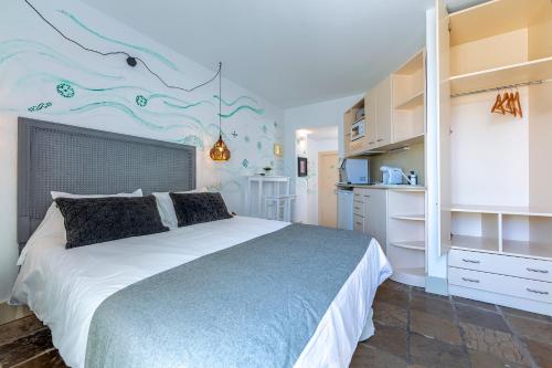 a bedroom with a large bed and a kitchen at La Casa de la Favorita in Tarifa