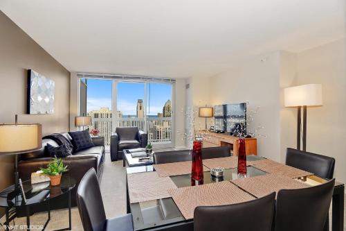 a living room with a couch and a table with chairs at The Penthouse at Grand Plaza in Chicago