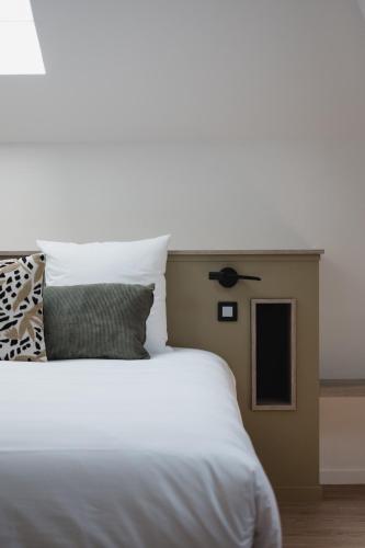 a bedroom with a white bed and a ceiling fan at Hôtel-Restaurant Villa Métis in Les Herbiers