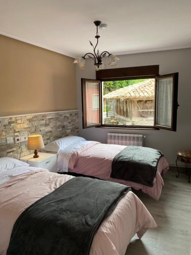 a bedroom with two beds and a window at Las tres Luces Casa 2 in Picones
