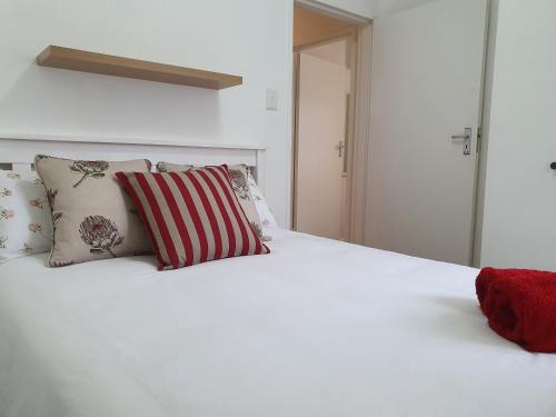 a white bed with pillows on top of it at Birdsong in Hermanus
