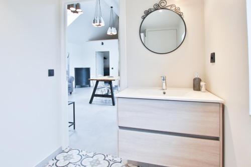 uma casa de banho com um lavatório e um espelho na parede em La Cense de Baudecet - La Fabrique em Gembloux