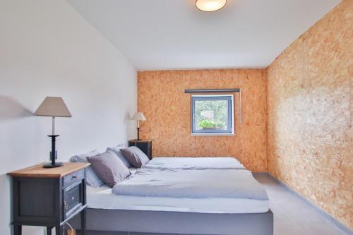 a bedroom with a bed and a window at La Cense de Baudecet - La Fabrique in Gembloux