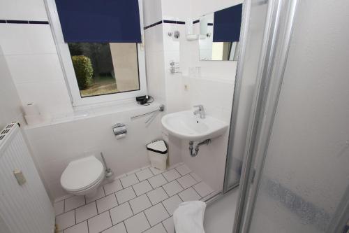 ein weißes Badezimmer mit Toilette und Waschbecken in der Unterkunft F-1010 Strandhaus Mönchgut Bed&Breakfast DZ 23 Terrasse, strandnah, inkl Frühstück in Lobbe