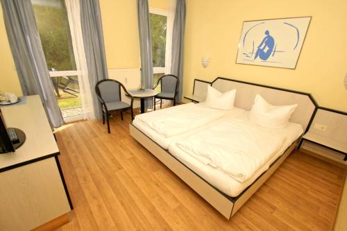 - une chambre avec un lit, une table et des chaises dans l'établissement F-1010 Strandhaus Mönchgut Bed&Breakfast DZ 26 Garten, strandnah, inkl Frühstück, à Lobbe