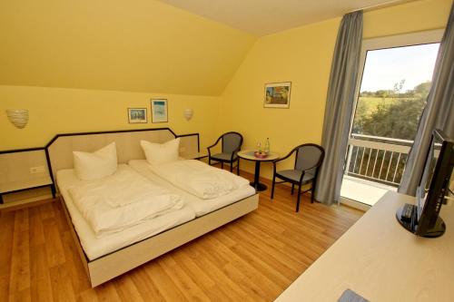 ロープベにあるF-1010 Strandhaus Mönchgut Bed&Breakfast DZ 31 Balkon, strandnah, inkl Frühstückのベッドルーム1室(ベッド1台、テーブル、椅子付)