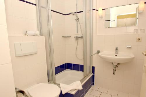 La salle de bains est pourvue d'une douche, de toilettes et d'un lavabo. dans l'établissement F-1010 Strandhaus Mönchgut Bed&Breakfast DZ 34 Balkon, strandnah inkl Frühstück, à Lobbe