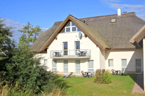 a large white house with tables and chairs at F-1010 Strandhaus Mönchgut Bed&Breakfast DZ 33 Balkon, strandnah, inkl Frühstück in Lobbe