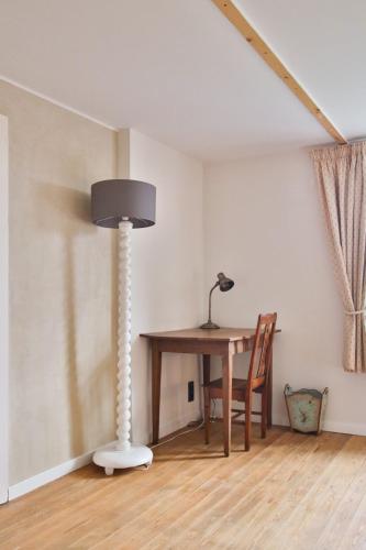 a table and a lamp in a room at La Cense de Baudecet - Le Corps de Logis in Gembloux