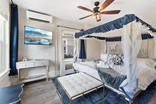 a bedroom with a canopy bed and a ceiling fan at King,Parking,AC,Deck,Train,Uni,Hospital in Bryn Mawr